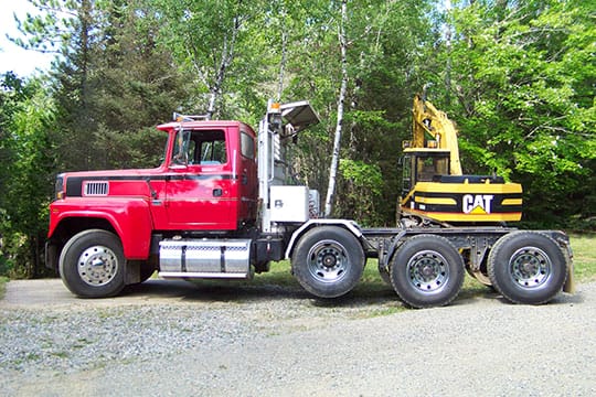 Red semi with equipment trailer
